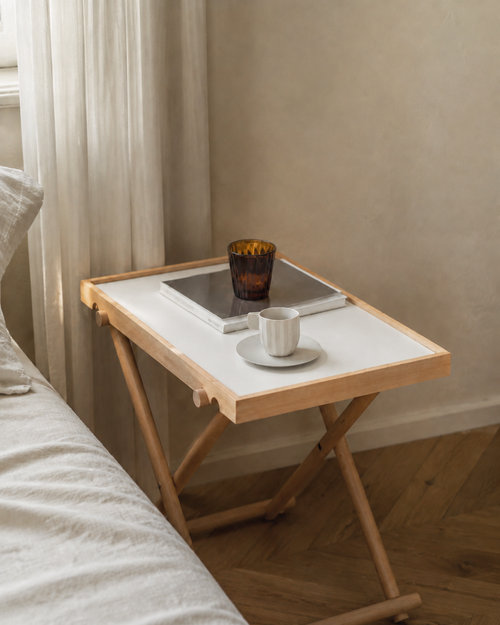 Pearl White Aster folding side table beside a bed